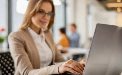 Junge Lehrperson (Frau) sitzt vor einem Laptop