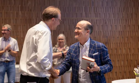 Hans Werner gratuliert Daniel Achermann im Careum Auditorium