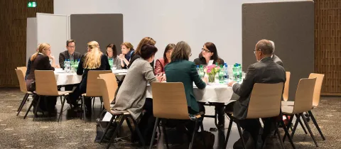 Seminarteilnehmer sitzen am Tisch und besprechen sich