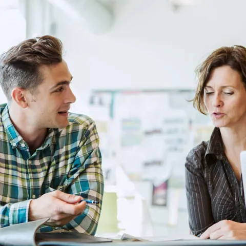 Eine Frau und ein Mann diskutieren ein Konzeptpapier