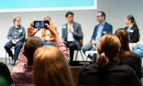 Ein Gast macht einen Schnappschuss vom Podiumsgespräch am Careum Forum 2026