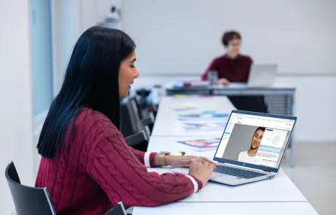 Lernende sitzt vor Laptop, auf dem der Lerncoach Navira von Sphere zu sehen ist.