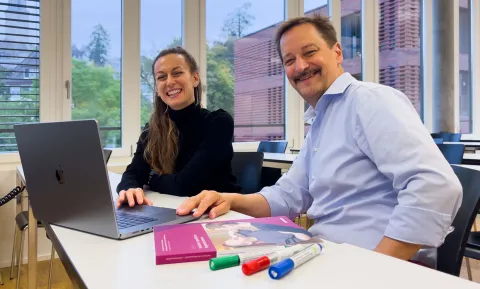 Die Projektleitungen für den Lerncoach Sphere sitzen in einem Klassenzimmer und lachen in die Kamera.